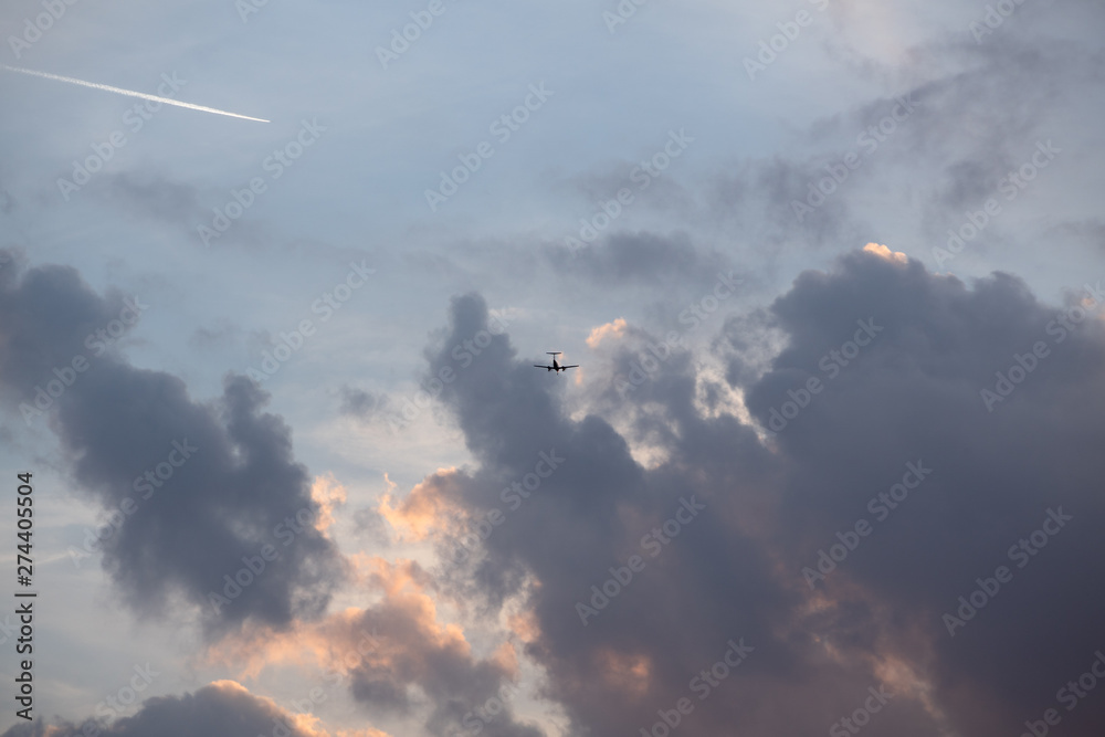Silhouette of a small aircraft entering a large cloud wall
