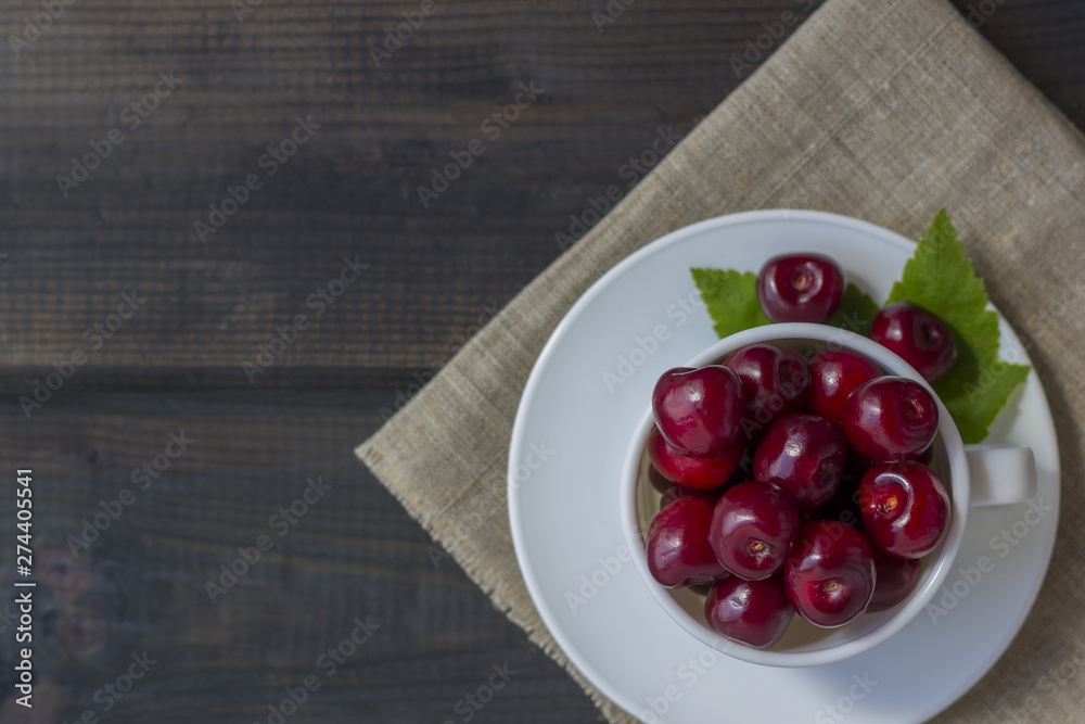 Fresh organic ripe sweet cherry in a white ceramic mug Fresh organic ripe sweet cherry in a white ceramic mug