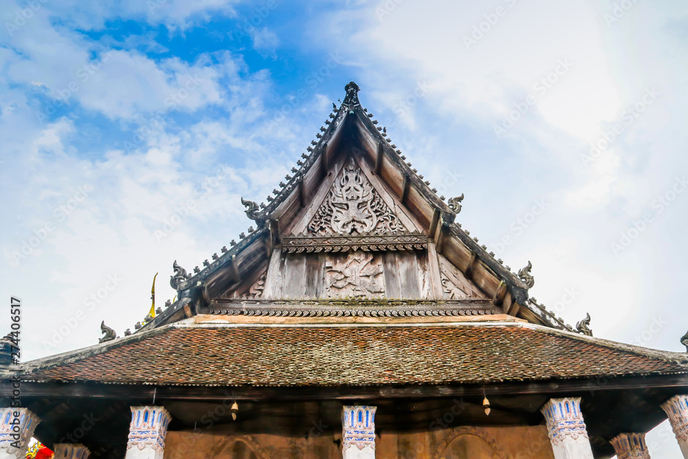 Old church isosceles made of wood on blue sky background