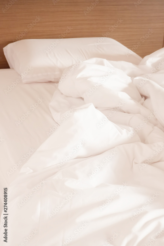 White crumpled bed sheet and messy pillows in a hotel room White crumpled bed sheet and messy pillows in a hotel room