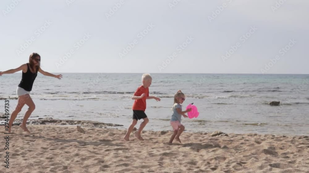 mother with children playing on the beach by the sea. A woman runs after children on the beach along the coast. Beautiful family videos from Cyprus holidays mother with children playing on the beach by the sea. A woman runs after children on the beach along the coast. Beautiful family videos from Cyprus holidays