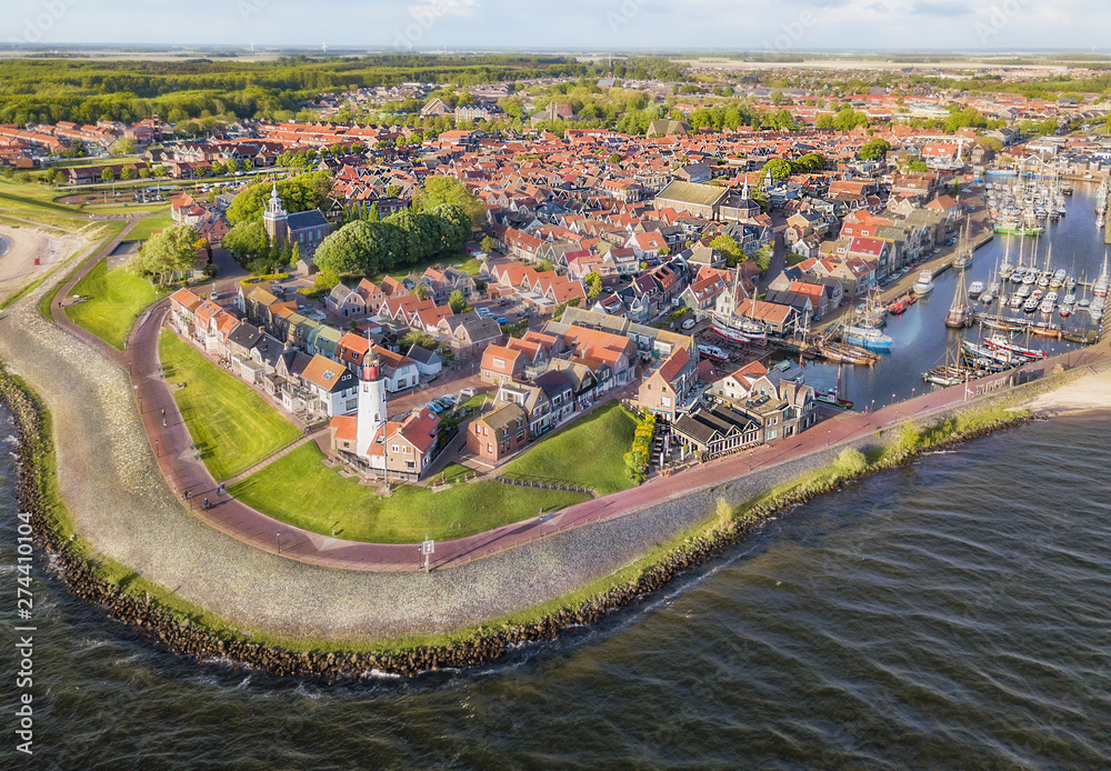 Aerial view of Urk with its lighthouse, a small coastal village on the IJsselmeer in the Netherlands.. - obrazy, fototapety, plakaty 