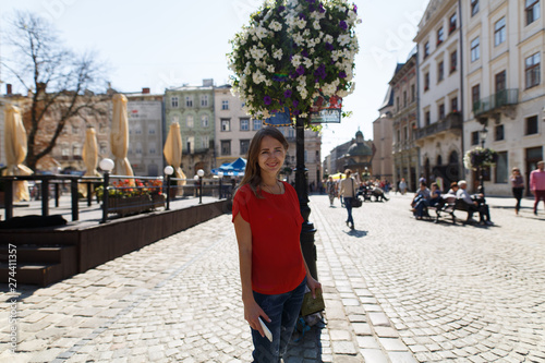 young smiling woman stands on the square in Lviv, Ukraine, against the background of old historical buildings. travel and tourism in Ukraine © mihail_pustovit