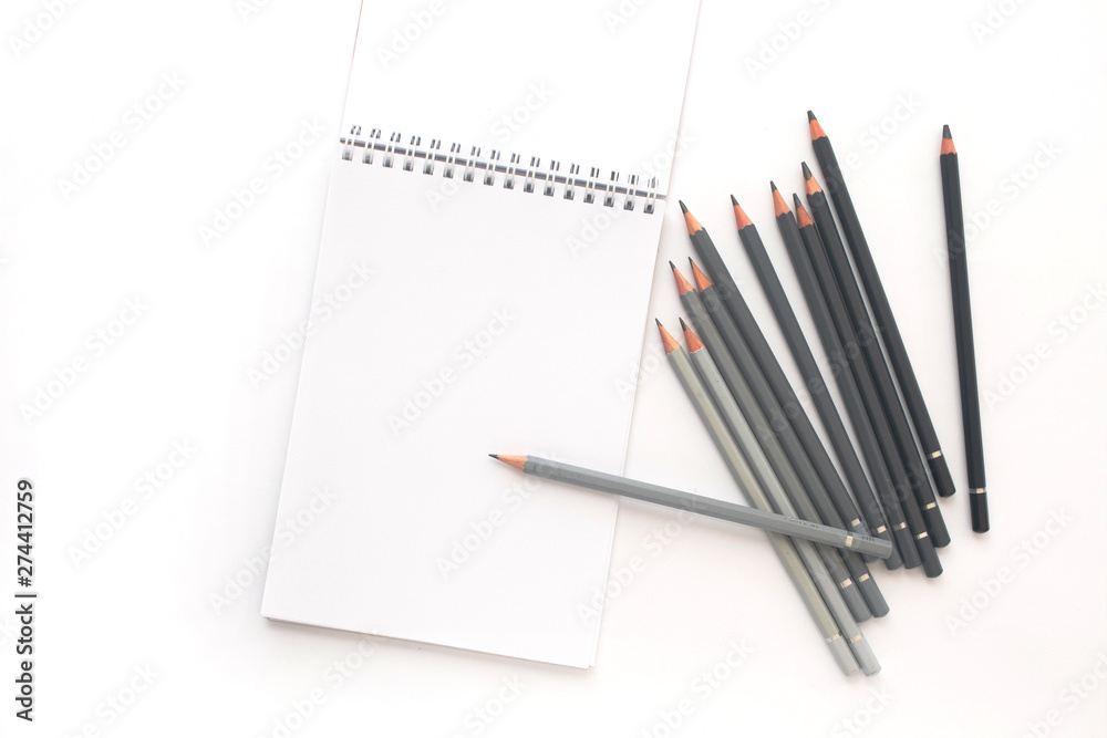 Notebook with pencils on a white background. Top view Notebook with pencils on a white background. Top view