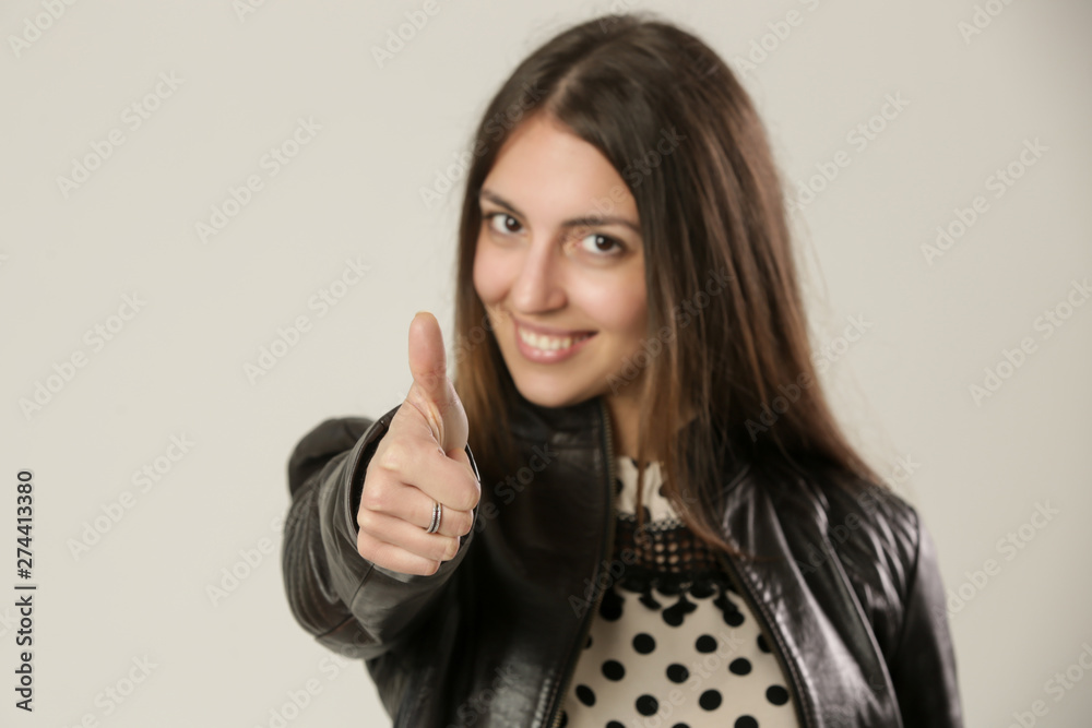 Studio portrait of a young woman giving a thumb up Studio portrait of a young woman giving a thumb up