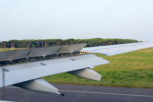Foto Close Up of a Wing of an Airplane with Flaps Up during the Taxiing on the Runway
