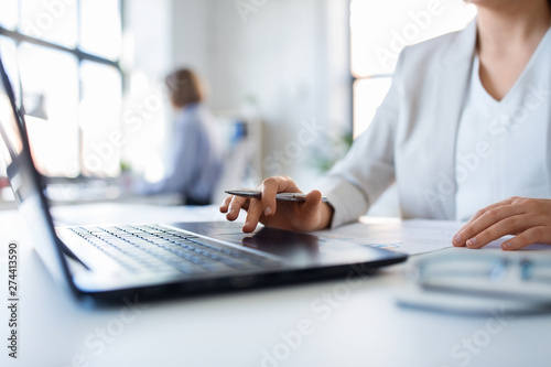 business and people concept - businesswoman with laptop computer and papers working at office