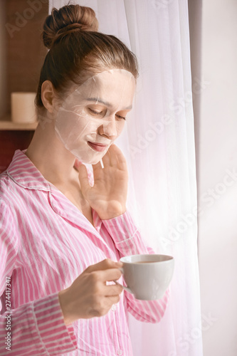 Young woman with sheet faci...