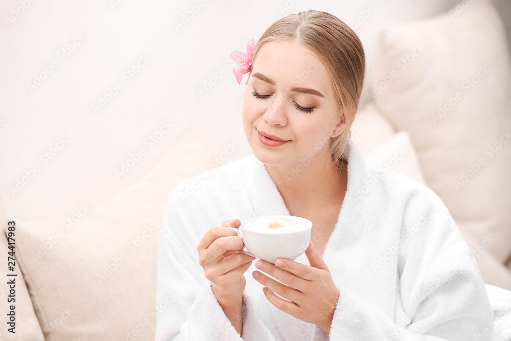Beautiful young woman drinking coffee in spa salon Beautiful young woman drinking coffee in spa salon