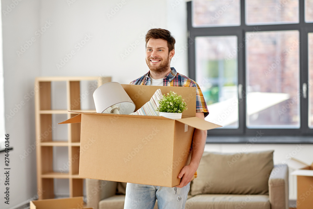 moving, people and real estate concept - happy man with boxes at new home moving, people and real estate concept - happy man with boxes at new home