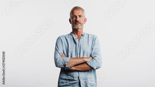 Foto Senior man standing with arms crossed
