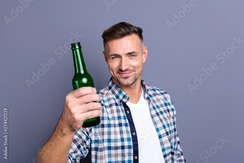 Close-up portrait of his he nice attractive cheerful bearded guy wearing checked shirt holding in hand light cold beer advice isolated over gray blue violet purple pastel background photo