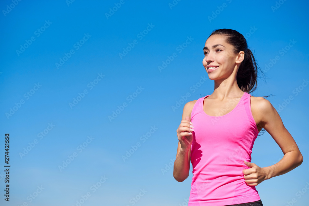 Running fitness woman. Training woman in pink top on a blue background Running fitness woman. Training woman in pink top on a blue background
