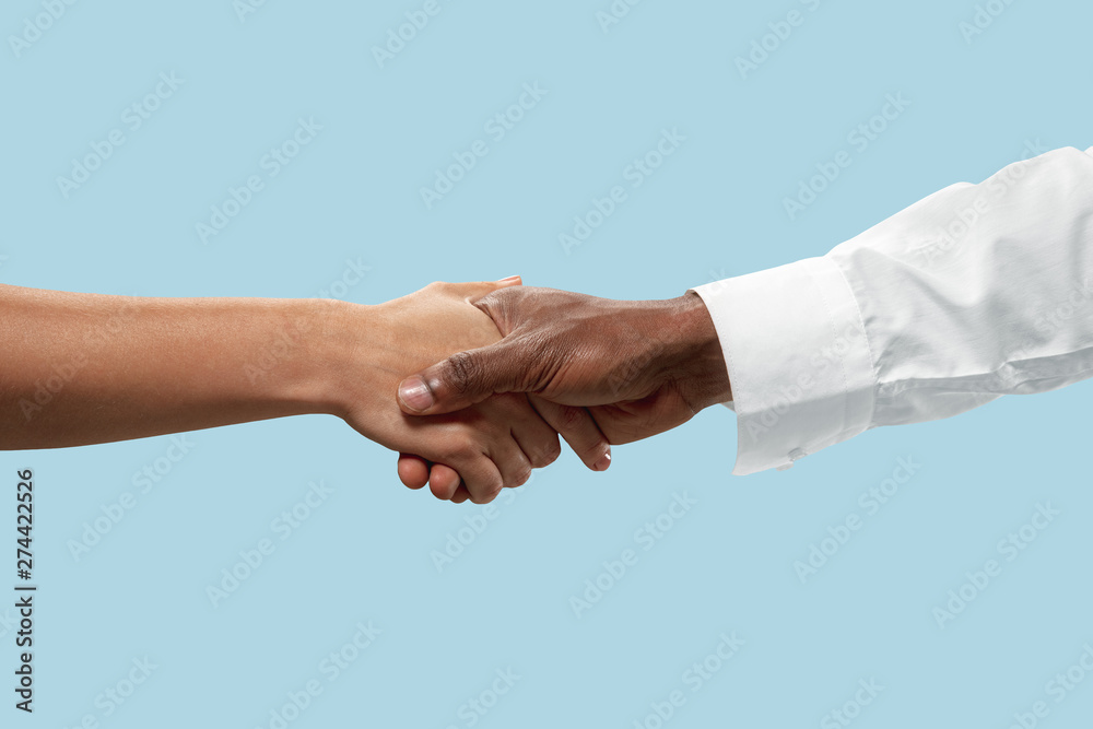 Joint plans for the future. Teamwork and communications. Male and female hands shaking isolated on blue studio background. Concept of help, partnership, friendship, relation, business, togetherness. Joint plans for the future. Teamwork and communications. Male and female hands shaking isolated on blue studio background. Concept of help, partnership, friendship, relation, business, togetherness.