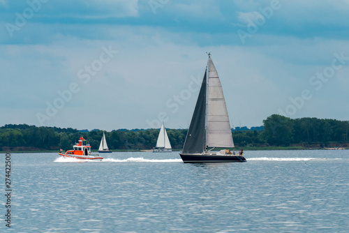 sea panorama with three sailing boats and a lifeboat