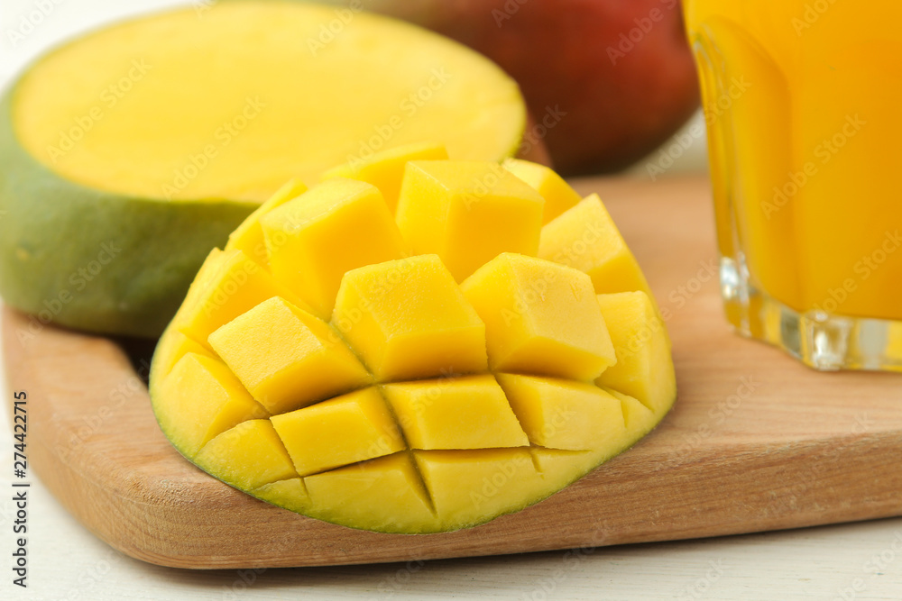 Ripe fresh mango fruit and slices and mango juice in a glass on a light background. tropical fruit. close-up Ripe fresh mango fruit and slices and mango juice in a glass on a light background. tropical fruit. close-up