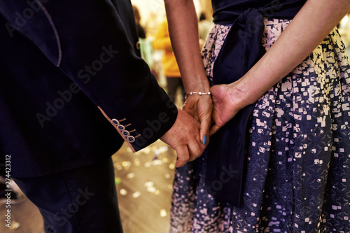 Close-up photo of lovers man and woman hold each other's hands. It is visible only hands of people.