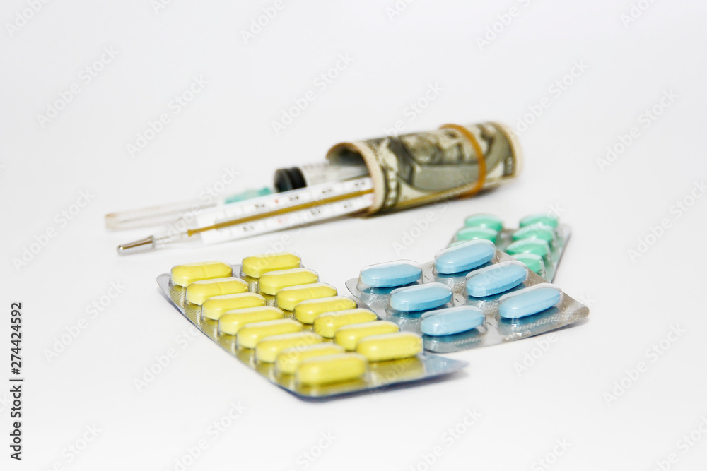 multi-colored medicinal pills, thermometer, syringe and dollars multi-colored medicinal pills, thermometer, syringe and dollars