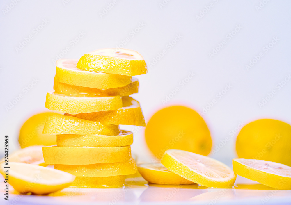 Set of several whole lemons with cutted one into slices, close up view. Yellow lemons on white background. Juicy lemon slices on light table. Blurred background. Selective soft focus Set of several whole lemons with cutted one into slices, close up view. Yellow lemons on white background. Juicy lemon slices on light table. Blurred background. Selective soft focus