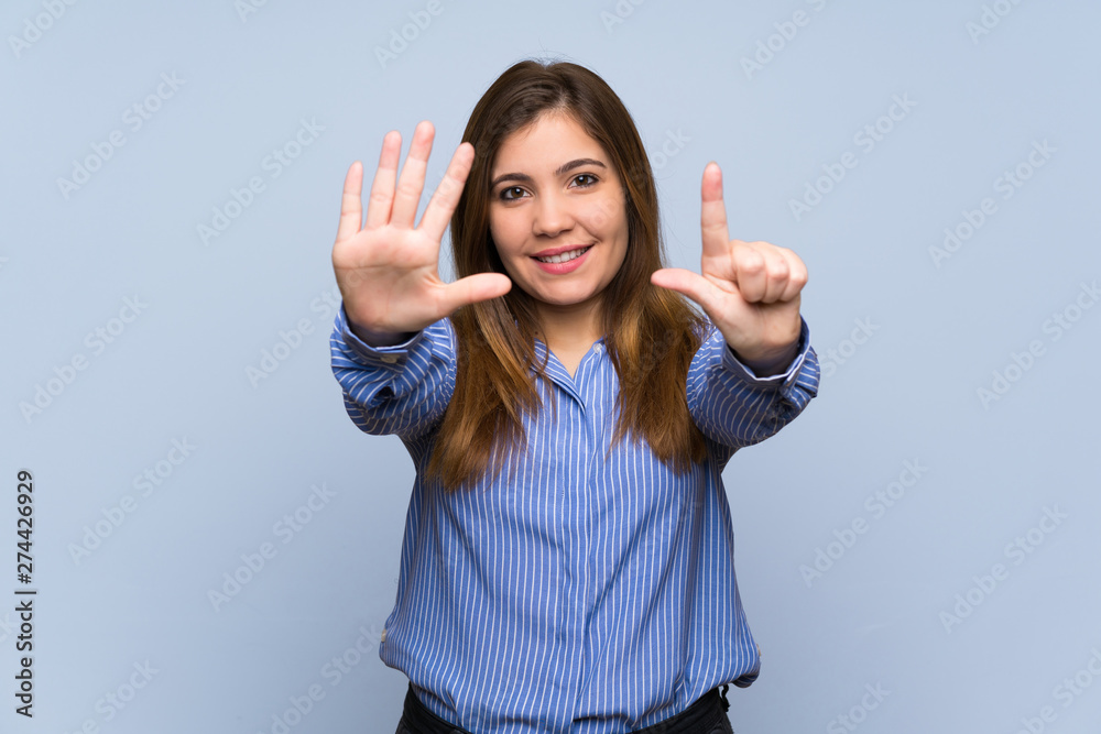 Young girl over isolated blue wall counting seven with fingers Young girl over isolated blue wall counting seven with fingers