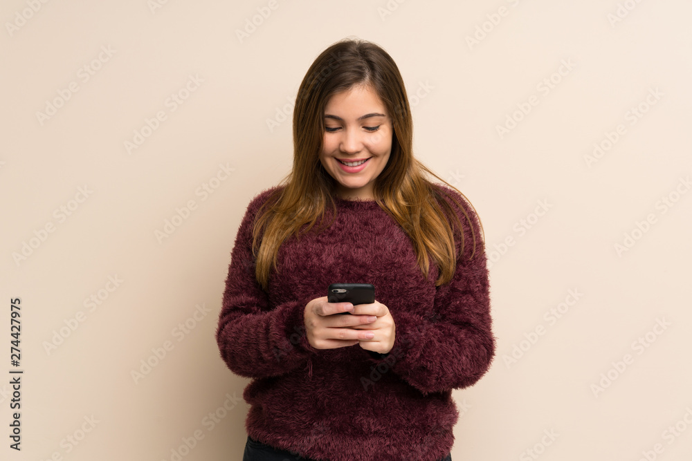 Young girl sending a message with the mobile Young girl sending a message with the mobile