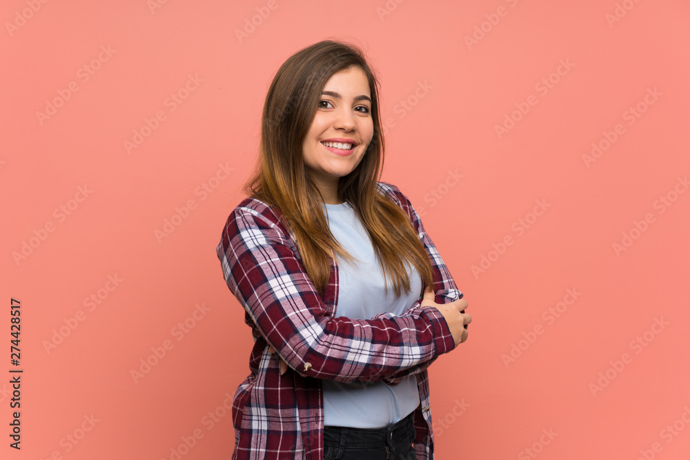 Young girl over pink wall with arms crossed and looking forward Young girl over pink wall with arms crossed and looking forward
