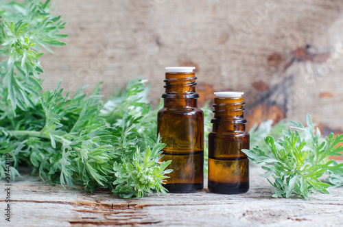 Fotografie Two small bottles with essential wormwood oil (extract, tincture, infusion)