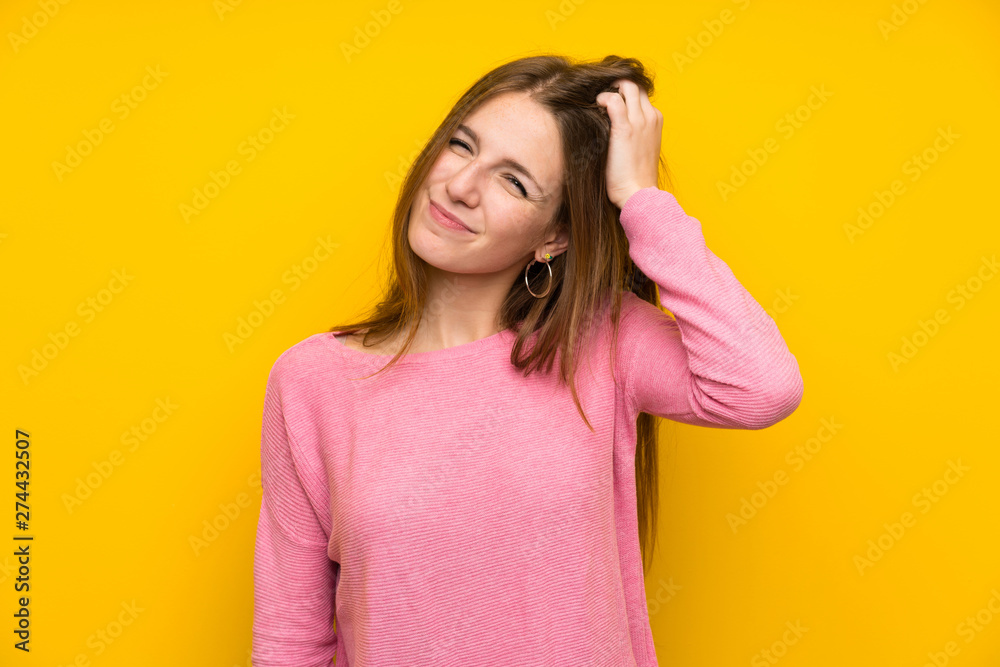 Young woman with long hair over isolated yellow wall with an expression of frustration and not understanding