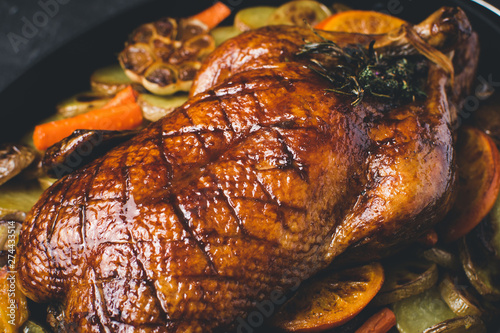 Roasted Goose with Carrots, Oranges and Potatoes on Dark Stone Background