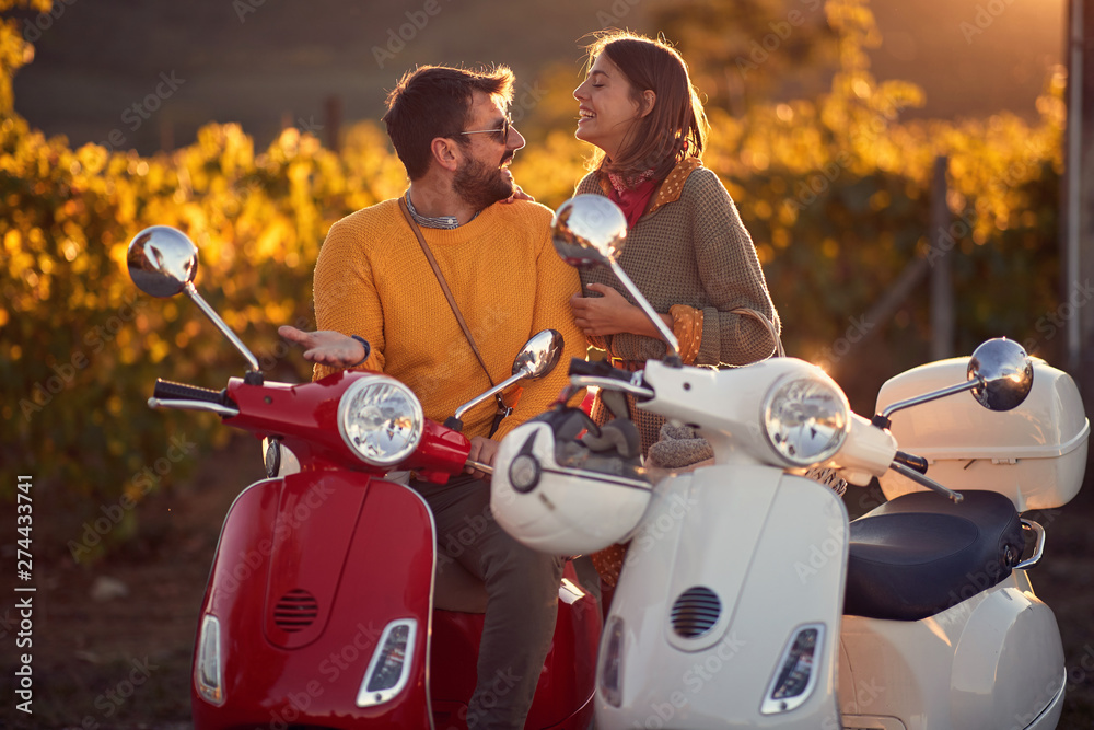 couple on scooter enjoying in romantic road trip.. Photos | Adobe Stock