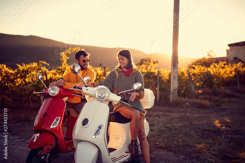 Photography Romantic couple riding on a scooter and enjoying road trip.