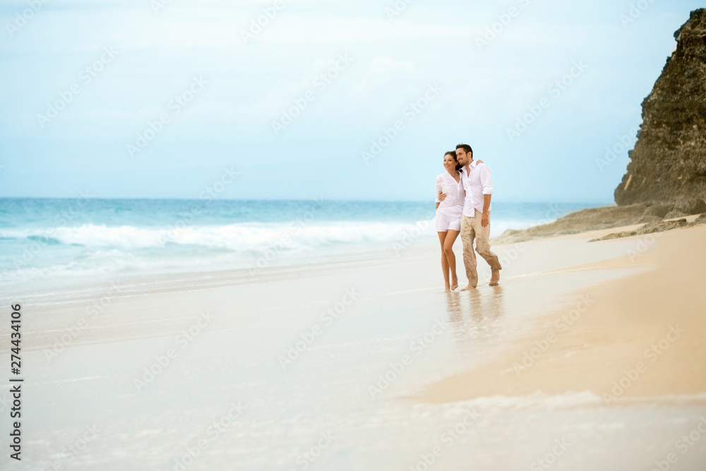 couple walking on a sandy beach