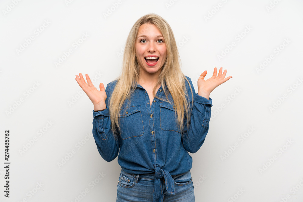 Young blonde woman over isolated white wall smiling a lot Young blonde woman over isolated white wall smiling a lot