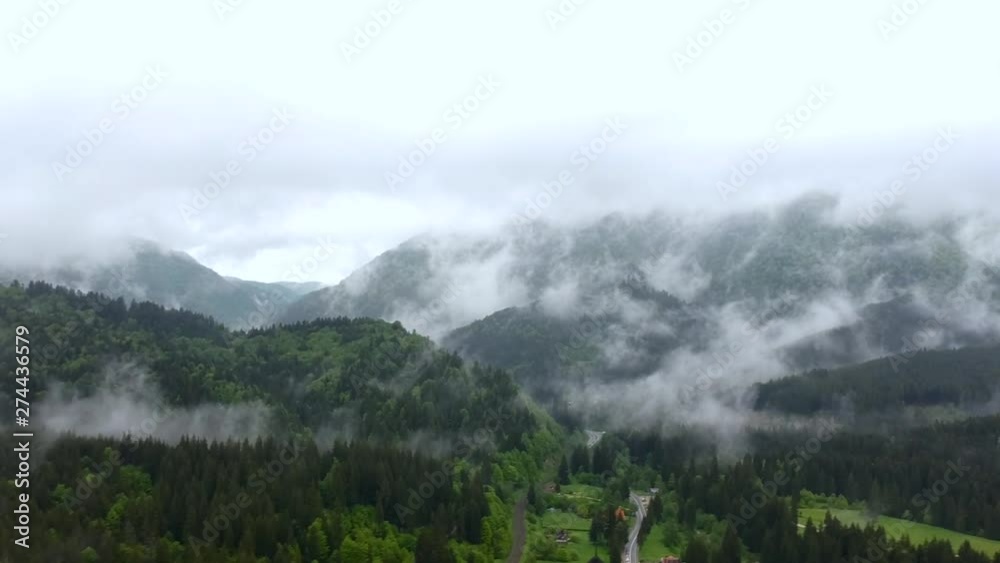Fanstastic Cinematic Aerial of Unreal Countryside Scenery With Morning Mist and Fog Under Mountain Summits Over Evergreen Forest Fanstastic Cinematic Aerial of Unreal Countryside Scenery With Morning Mist and Fog Under Mountain Summits Over Evergreen Forest