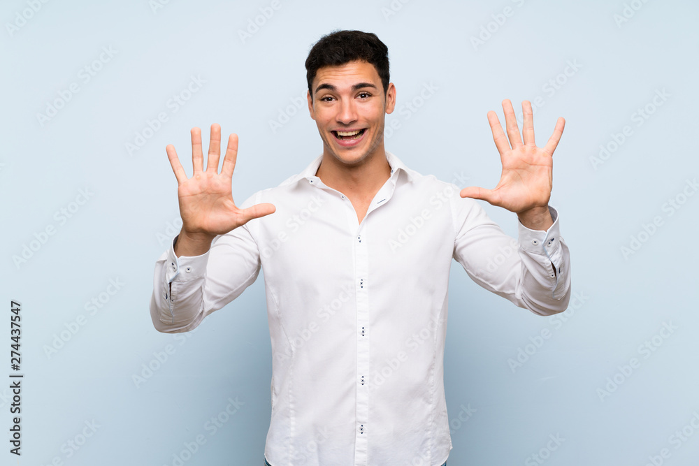 Handsome man over blue wall counting ten with fingers Handsome man over blue wall counting ten with fingers