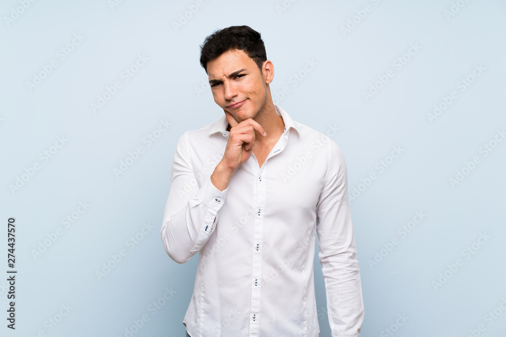 Handsome man over blue wall Looking front Handsome man over blue wall Looking front