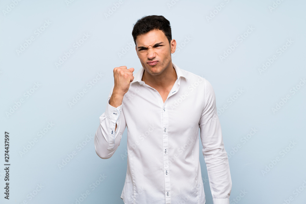 Handsome man over blue wall with angry gesture Handsome man over blue wall with angry gesture