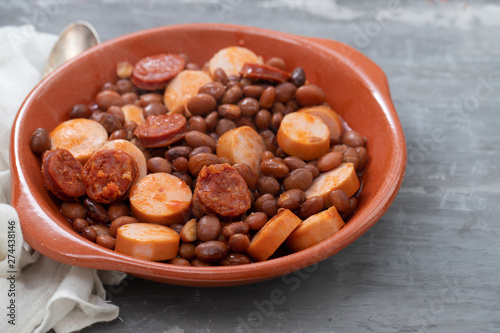 beans with smoked sausages and sausages in ceramic dish