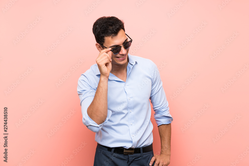 Handsome man over pink background with glasses and happy Handsome man over pink background with glasses and happy