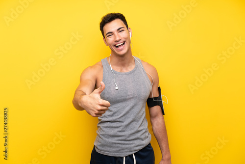 Fototapeta Naklejka Na Ścianę i Meble -  Handsome sport man over isolated background with thumbs up because something good has happened