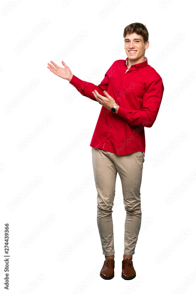 A full-length shot of a Handsome young man extending hands to the side for inviting to come over isolated white background A full-length shot of a Handsome young man extending hands to the side for inviting to come over isolated white background