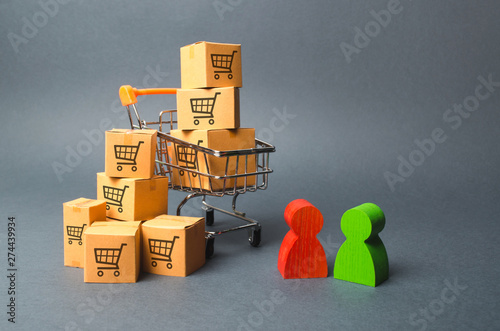 Fotografie Shopping cart with cardboard boxes with a pattern of trading carts a buyer and seller, manufacturer and retailer