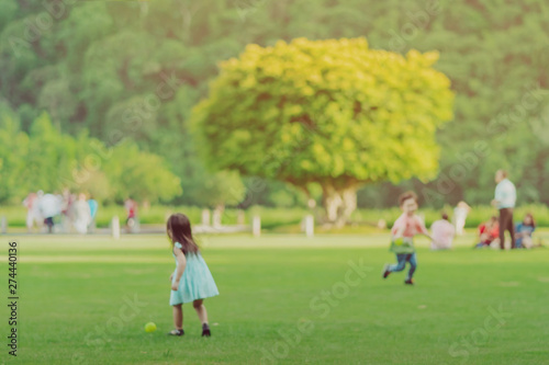 Blur image of Kid enjoy to playing with little ball on green field