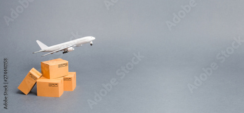 Airplane and stack of cardboard boxes. concept of air cargo and parcels, airmail. Fast delivery of goods and products. Cargo aircraft. Logistics, connection to hard-to-reach places. Banner, copy space