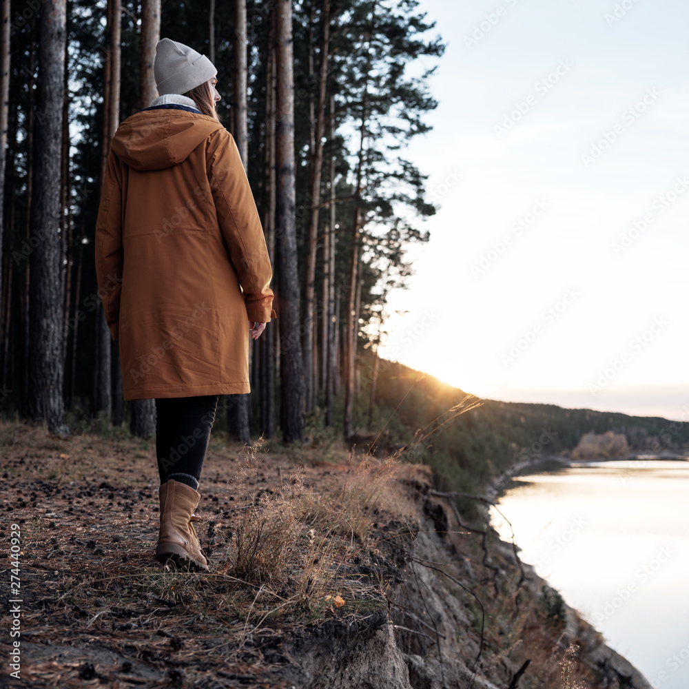 Female hiker walking on bank of river Female hiker walking on bank of river