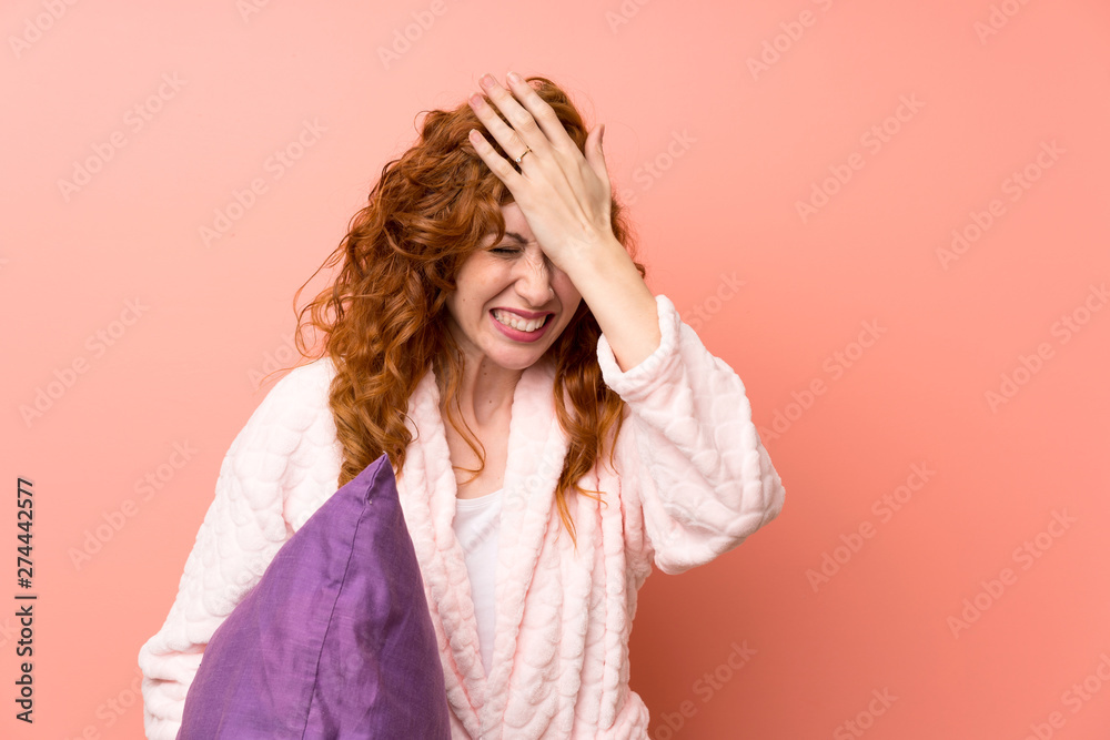 Fototapeta premium Redhead woman in dressing gown having doubts with confuse face expression