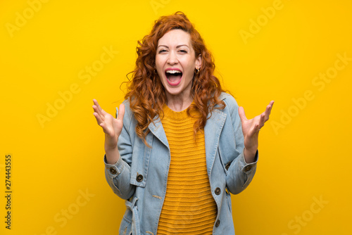 Redhead woman over isolated yellow background unhappy and frustrated with something