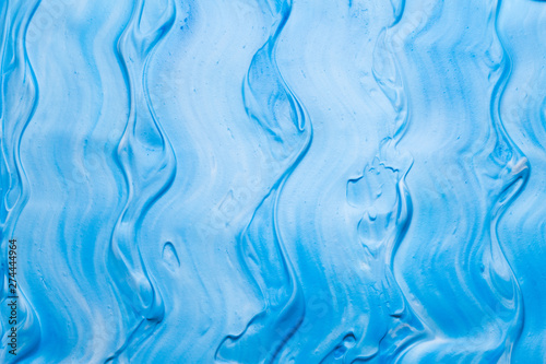 Blue and white acrylic paint art background. Colored whipped cream. Sea waves effect surface.