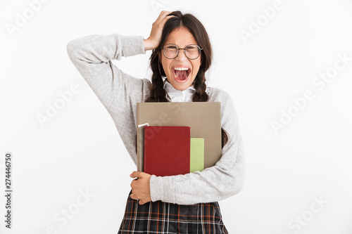 Photo closeup of nervous teenage girl wearing eyeglasses stressing and grabbing her head while holding studying books