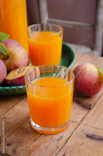 Fresh homemade peach juice in glass for breakfast on wooden table .Rustic stile. Free text space.